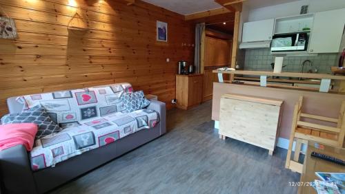 un salon avec un canapé et une cuisine dans l'établissement Joli appartement situé à l'entrée du Val Claret, à Tignes