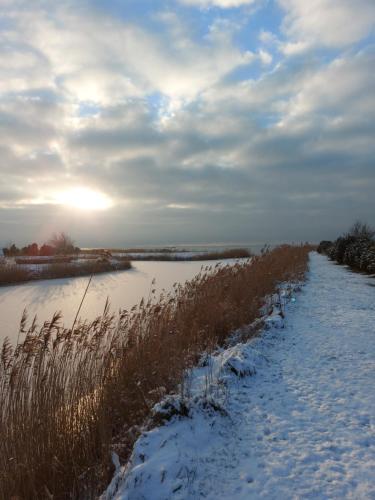 a river with snow on the side of it at Svenceles 25 sodyba Namas su pirtimi ir krantine in Svenele