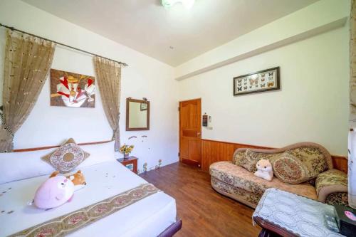 a living room with a bed and a couch at Sweetheart Homestay in Luodong