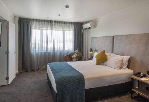 a hotel room with a large bed and a window at Sudima Hotel Lake Rotorua in Rotorua