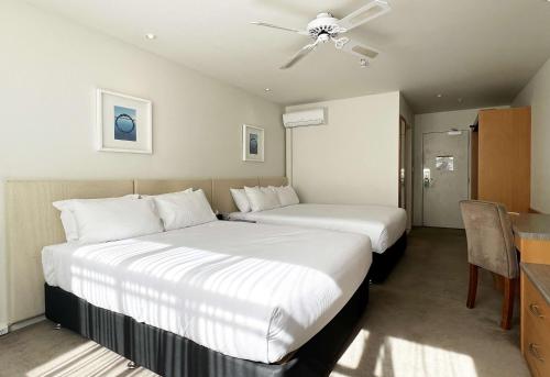a hotel room with two beds and a ceiling fan at Sudima Hotel Lake Rotorua in Rotorua