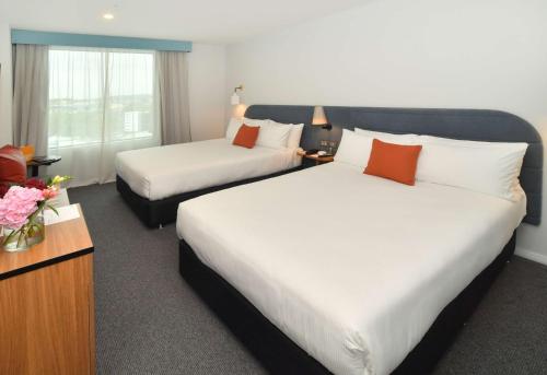 a hotel room with two beds and a tv at Sudima Auckland City in Auckland