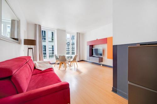 un salon avec un canapé rouge et une table dans l'établissement Paris Marais Maison Lombard, à Paris