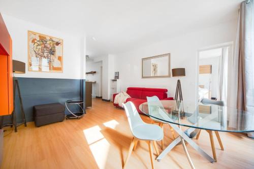 - un salon avec une table en verre et un canapé rouge dans l'établissement Paris Marais Maison Lombard, à Paris