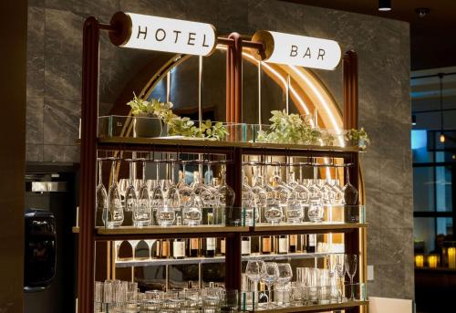 a shelf filled with glasses in a bar at Sudima Auckland City in Auckland