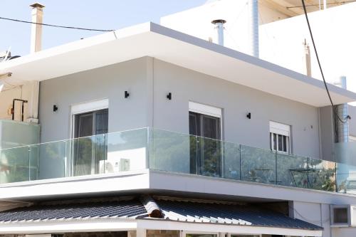 an external view of a building with a glass balcony at The Pines apartment in Palaiá Fókaia