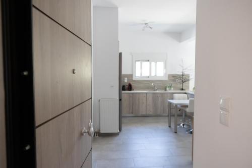 a kitchen with a white refrigerator and a table at The Pines apartment in Palaiá Fókaia