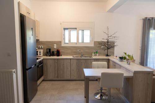 a kitchen with a refrigerator and a table in it at The Pines apartment in Palaiá Fókaia