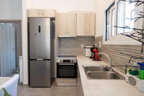 a kitchen with a stainless steel refrigerator and a sink at The Pines apartment in Palaiá Fókaia
