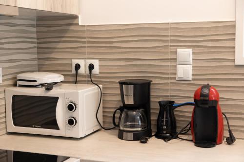 a kitchen counter with a microwave and a blender at The Pines apartment in Palaiá Fókaia