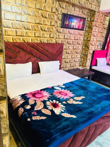 a bedroom with a bed with a blue blanket on it at The Aziz Residency in New Delhi