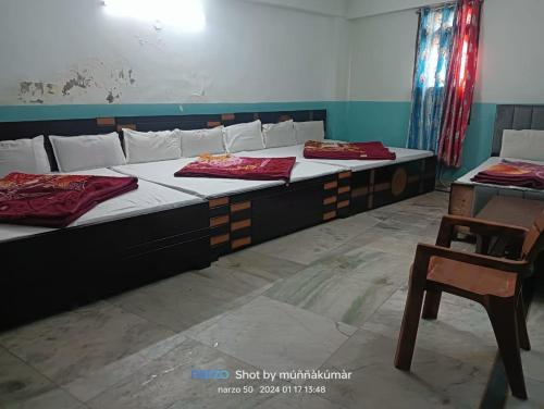 two beds in a room with a table and a chair at The Aziz Residency in New Delhi