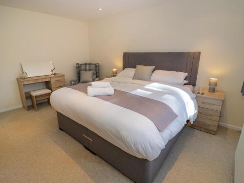 ein großes Schlafzimmer mit einem großen Bett mit weißer Bettwäsche in der Unterkunft Fenny Marina Cottage in Southam