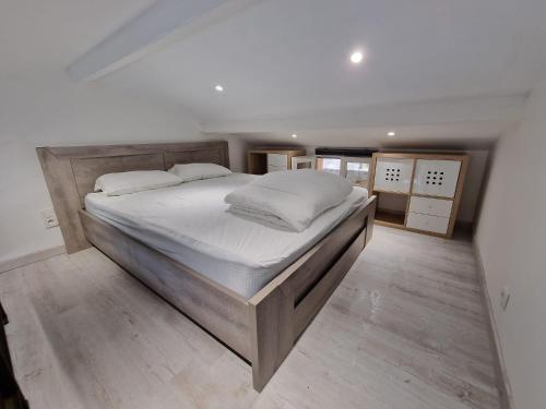 une chambre avec un grand lit avec des draps blancs dans l'établissement Jolie petit mazet à 10min des plages, à Rayol-Canadel-sur-Mer