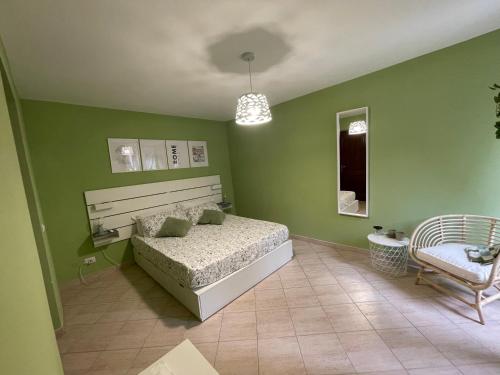 a bedroom with green walls and a bed and a chair at Castrum Home - Castelli Apartments in Castel Gandolfo