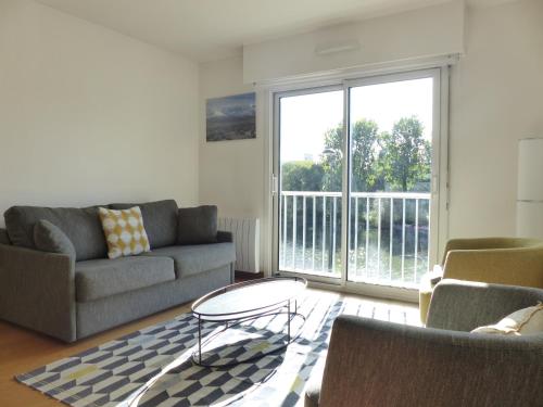 un salon avec un canapé et une table basse dans l'établissement La Fontaine,T2 au calme , parking, vue Erdre, à Nantes