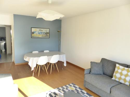 un salon avec une table et un canapé dans l'établissement La Fontaine,T2 au calme , parking, vue Erdre, à Nantes