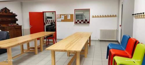 Cette chambre dispose de tables en bois et de chaises colorées. dans l'établissement Chalet du CUPau, à Cauterets