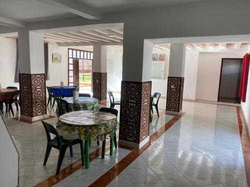 a dining room with a table and chairs in a room at Hotel camping amtoudi in Id AÃ¯ssa