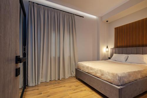 a bedroom with a bed and a large window at Noir Residence - Chic 2Br House Near Maleme Beach in Maleme