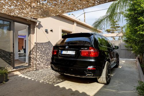 a black car parked outside of a house at Noir Residence - Chic 2Br House Near Maleme Beach in Maleme