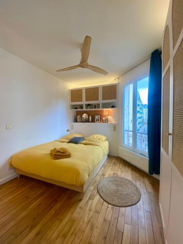 - une chambre avec un grand lit jaune et une fenêtre dans l'établissement studio lumineux - Jonquière, à Paris
