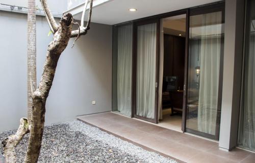 a room with glass doors and a tree at Hyarta Villa 3 BR Block C in Kejayan