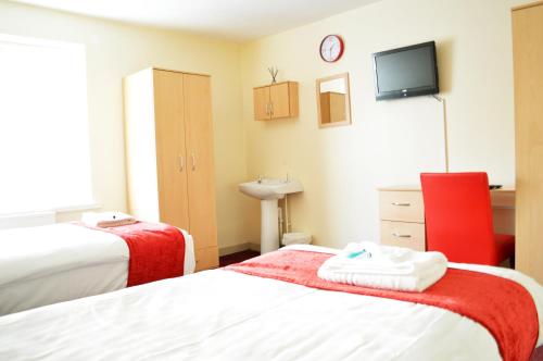 a bedroom with two beds and a tv on the wall at Hotel Express Newcastle Gateshead in Newcastle upon Tyne