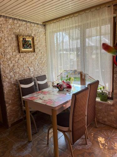 a dining room with a table and four chairs at Cottage 'Carolina' with hot tub, sauna and BBQ area in Kosiv