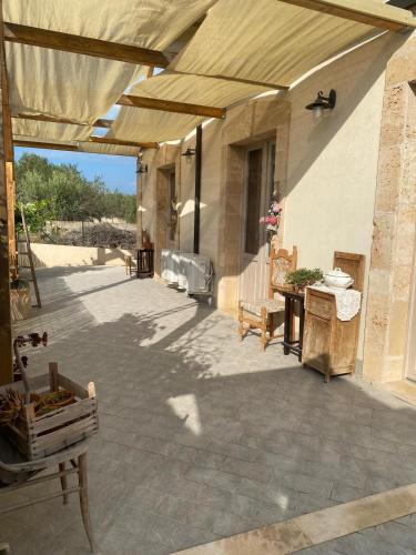 an outdoor patio with a large umbrella and a table at Bàcula Nzícula Marzamemi in Marzamemi