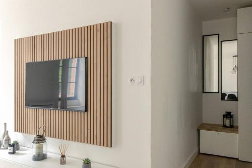 a living room with a television on a wall at Appartement Albi Parking Gratuit in Albi