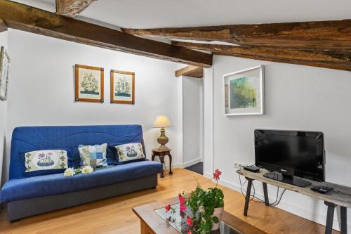 un salon avec un canapé bleu et une télévision dans l'établissement Apartamento 2, à Selores