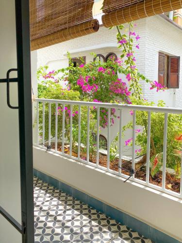 an open door to a balcony with pink flowers at DƯỚI TÁN CÂY homestay in Tây Ninh