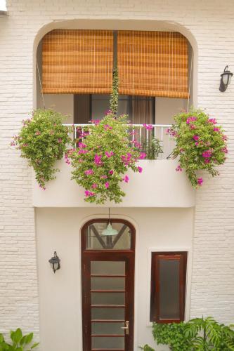 a building with a door and flowers on a balcony at DƯỚI TÁN CÂY homestay in Tây Ninh
