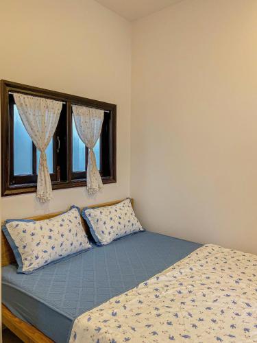 a bedroom with a bed and two windows at DƯỚI TÁN CÂY homestay in Tây Ninh