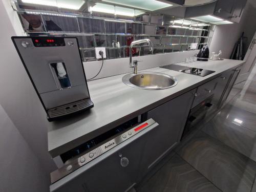 una cucina con lavandino e bancone con forno a microonde di Maxim Apartment Pobierowo a Pobierowo