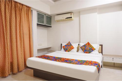a bedroom with a bed and a window at FabExpress Shree Haree Residency - Nr Mazda Garden View in Pune