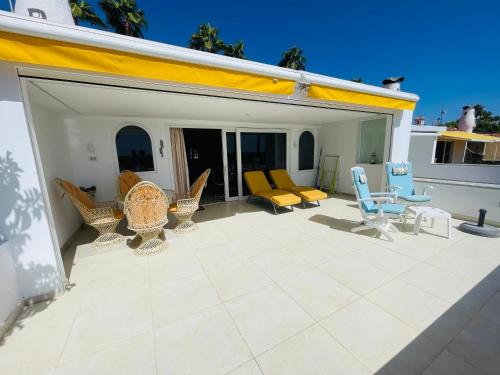 a patio with chairs and furniture on a building at Seaview Bungalow Duna Golf in Playa del Ingles