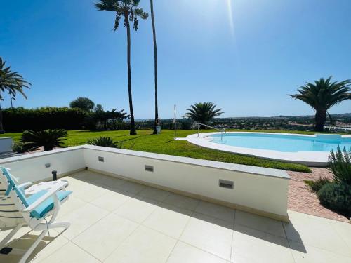 a patio with two chairs and a swimming pool at Seaview Bungalow Duna Golf in Playa del Ingles