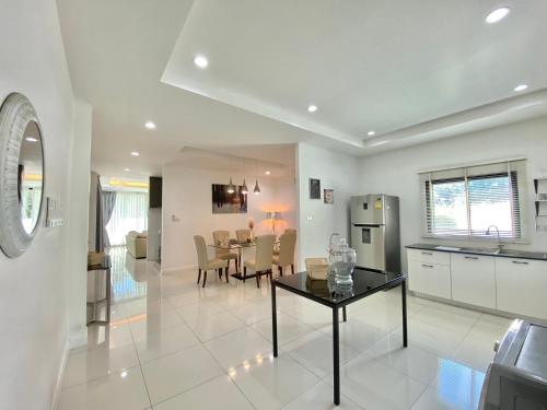 a kitchen and living room with a table and a dining room at White Tara Villa in Chiang Mai