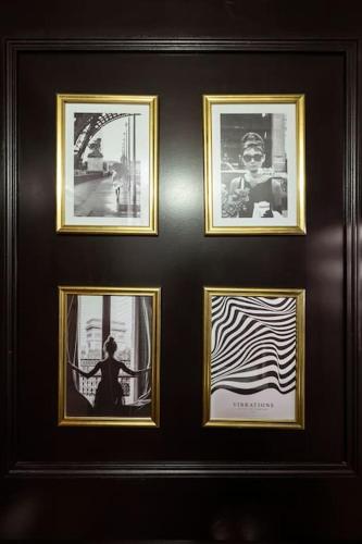 a group of four pictures on a wall at Jacuzzi Deluxe - Penthouse in Saint-Maur-des-Fossés