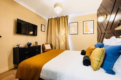 a bedroom with a large bed with blue and yellow pillows at Jacuzzi Deluxe - Penthouse in Saint-Maur-des-Fossés