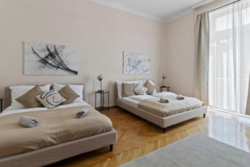 Un dormitorio con dos camas y una gran ventana. en At Belvedere, Top Location Close to U1, en Viena