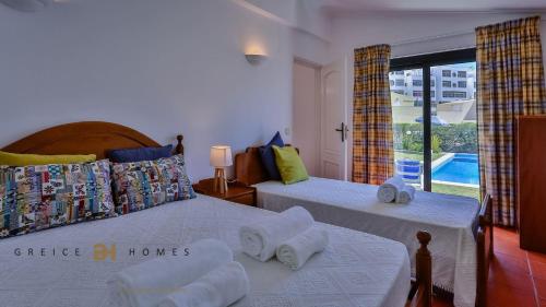 two beds in a bedroom with a view of a pool at Greice Homes-650 meters from the beach, 4 bedrooms villa for holidays in Vilamoura-Quarteira in Quarteira