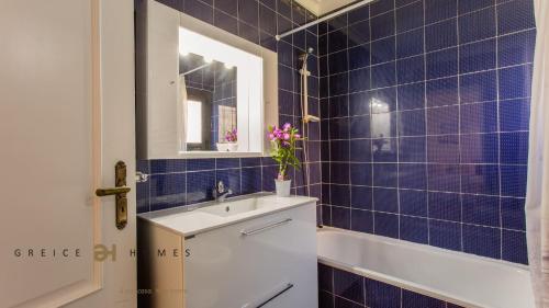 a blue tiled bathroom with a sink and a tub at Greice Homes-650 meters from the beach, 4 bedrooms villa for holidays in Vilamoura-Quarteira in Quarteira