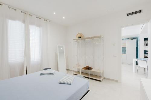 Un dormitorio blanco con una cama y una mesa. en Viky Vacanze a San Vito Lo Capo, en San Vito lo Capo