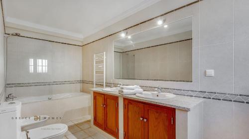 a bathroom with a sink and a toilet and a tub at Luxuosa moradia V5 em Quarteira - Greice Homes in Quarteira