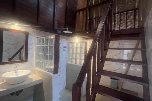 a bathroom with a sink and a wooden staircase at Rama Garden Lembongan in Nusa Lembongan