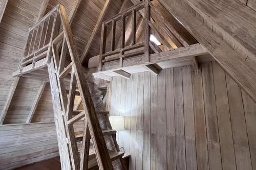 an attic room with wooden stairs in a building at Rama Garden Lembongan in Nusa Lembongan
