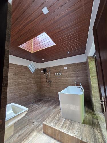 a bathroom with a skylight and a tub and a sink at Villa D55 in Kandy